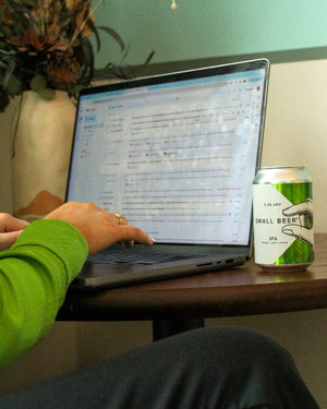 Can of IPA next to a laptop