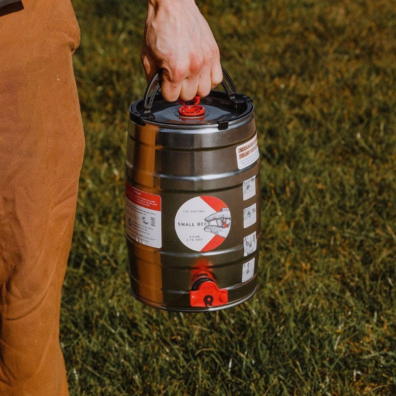 
            
                Load image into Gallery viewer, Person carrying a 5L Mini Keg of Small Beer Steam
            
        